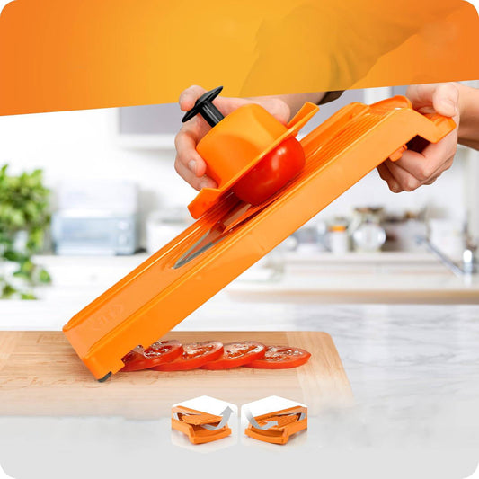 Mandoline à lame en v de couleur orange qui coupe une tomate en tranche régulière. 